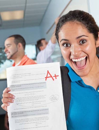 Happy Female Student in Class With Great Test Grade.